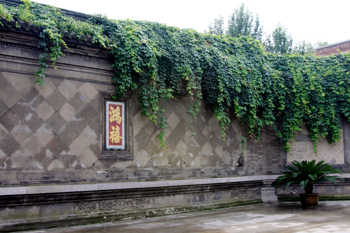 图为帅府东院大门前的影壁墙,上镶嵌"鸿禧"两个大字