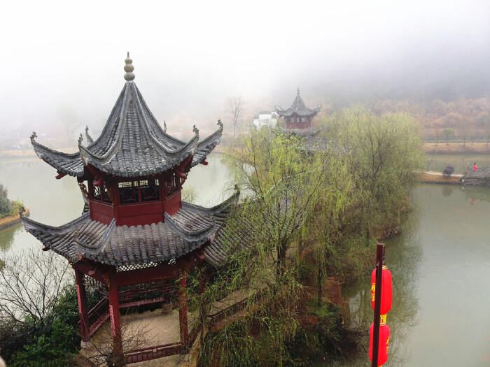 站在古楼上眺望亭台楼阁及远处雨中的群山.