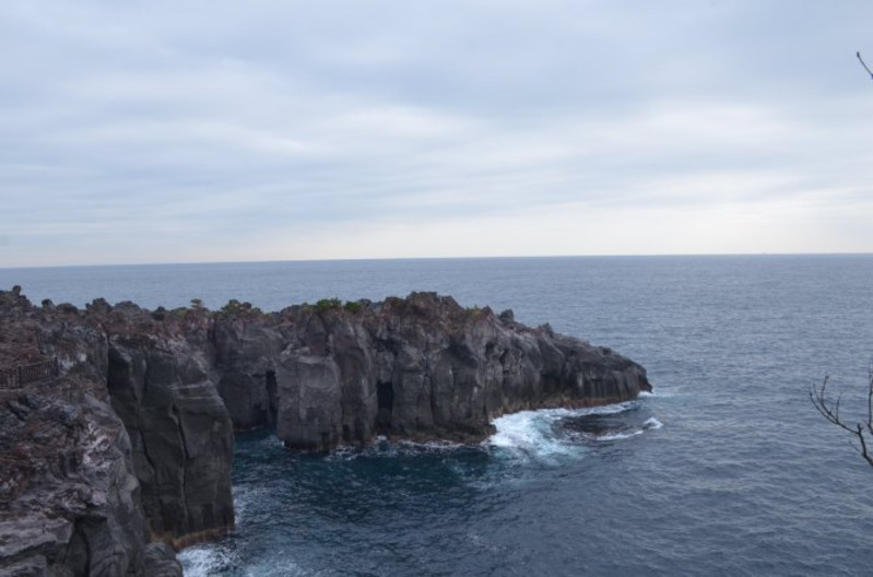 来到海岸边,峭壁礁石嶙峋,惊涛拍岸,阴天