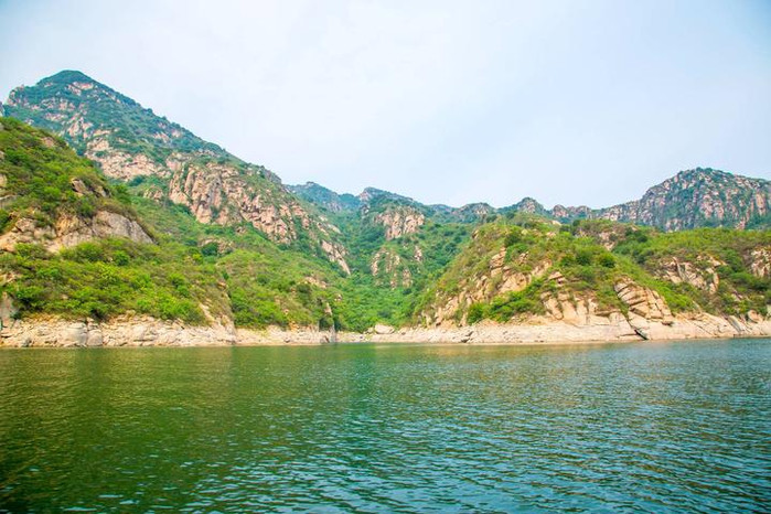 狭长的龙峡湖两岸是高山,湖边是怪石嶙峋,这张图上的石头就像一个背靠