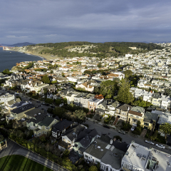 Unique aerial view from above San Francisco's Lincoln Park, looking towards the east and showing the Golden Gate Bridge, the Presidio, and downtown in the distance