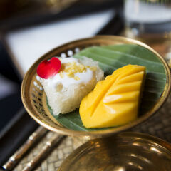 Thai mango sticky rice served on brass platter