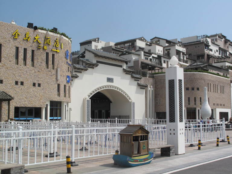 舟山普陀金岛大酒店位于舟山旅游集散中心---朱家尖慈航广场、蜈蚣峙客运中心,与普陀山隔海相望。酒店所在的广场有6万元多平方建筑面积的旅游配套公共设施,距离蜈蚣峙客运中心售票大厅近在咫尺;大巴、公交等交通选择多样;前往普陀山机场、朱家尖南沙国际沙雕广场、普陀印象实景表演(白山景区)、乌石塘景区、普陀国际游艇俱乐部、大青山生态林等著名景点都非常方便。<br>舟山普陀金岛大酒店经普陀山风景名胜区管理委员会批准设立,占地面积3000多平方米。各类舒适客房内配有中央空调、24小时中央热水