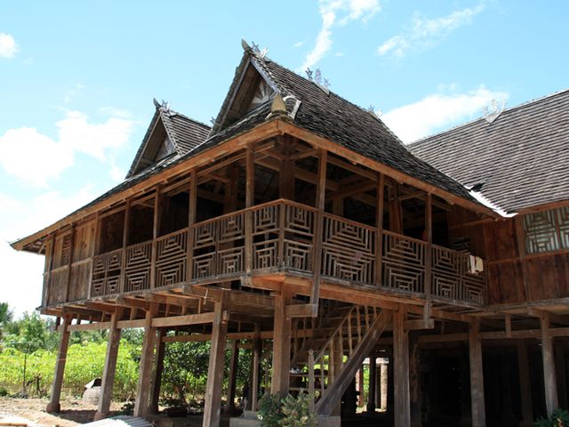 傣家竹楼为杆栏式的建筑,造型美观,外形像个架在高柱上的大帐篷.