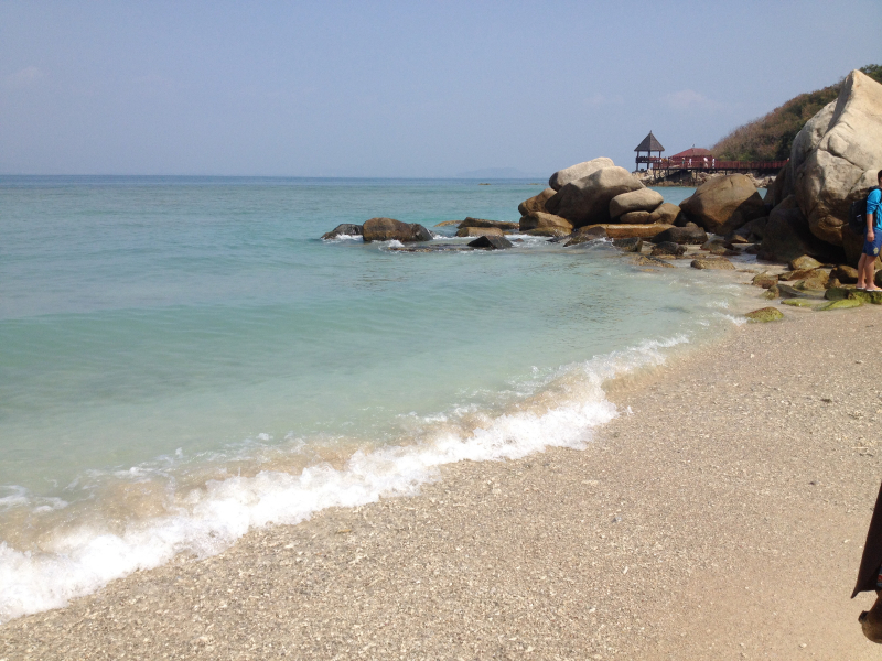 基岩海岸,海水清澈,海上礁石众多,不远处有