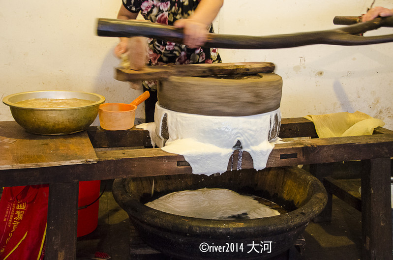 经过了周庄十二坊的豆腐坊,店主正在磨豆腐,传统工艺,石磨