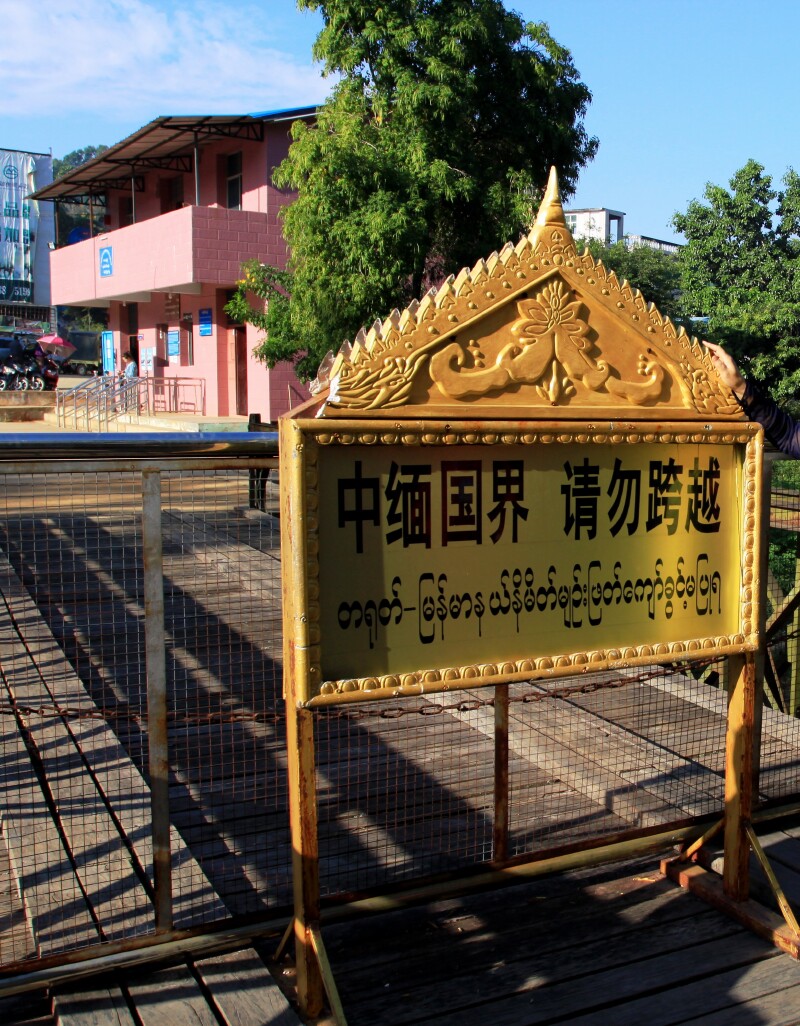 九谷的桥上,看到来往的车辆边民,畹町河对岸缅甸九谷镇飘动缅甸的旗帜