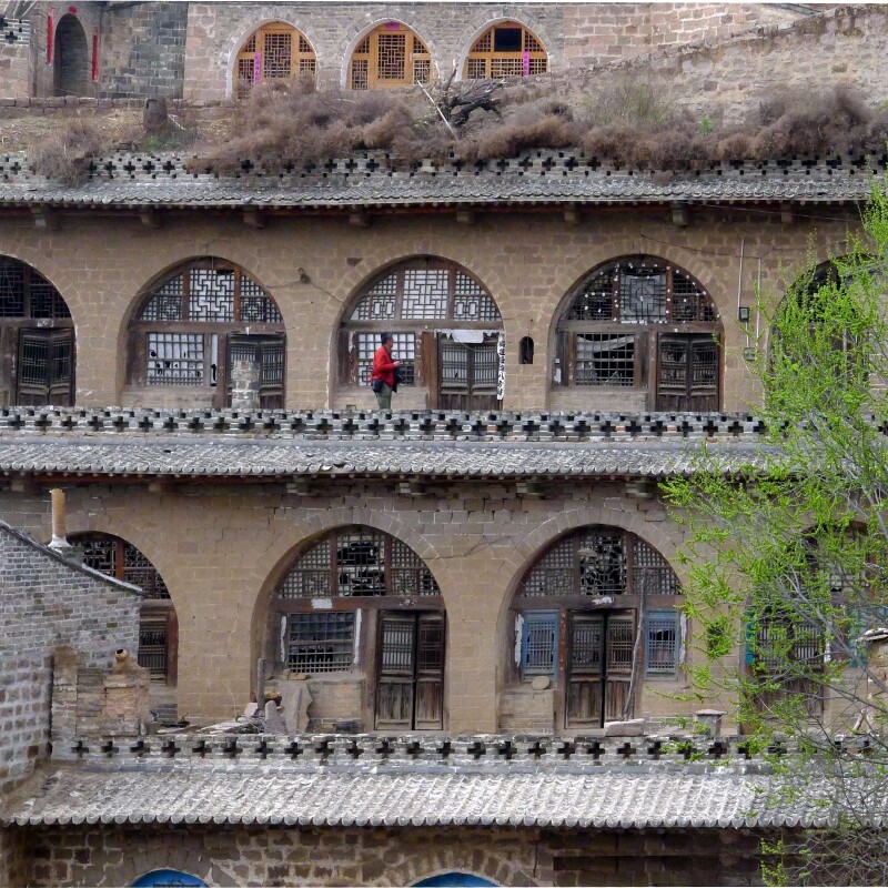 山坳里依山建起的立体村落,窑洞层层叠置错落,并不是土窑,而是大块石