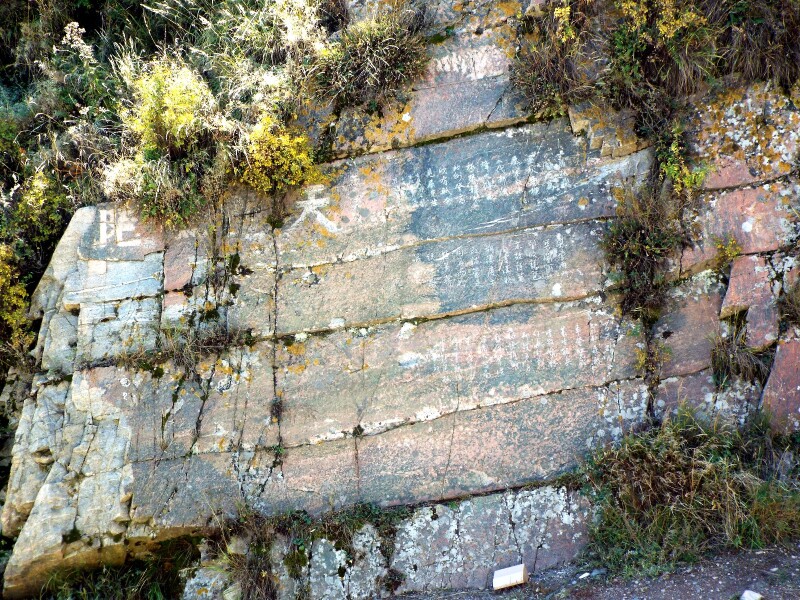 驿站对面崖壁上隐约可辨的刻石文字.