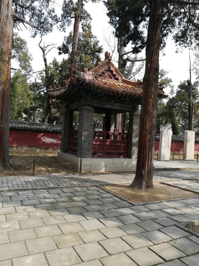 亭筑于三级台阶之上,单檐歇山式,黄琉璃瓦覆顶,灰砖立四角墙,红色花棂