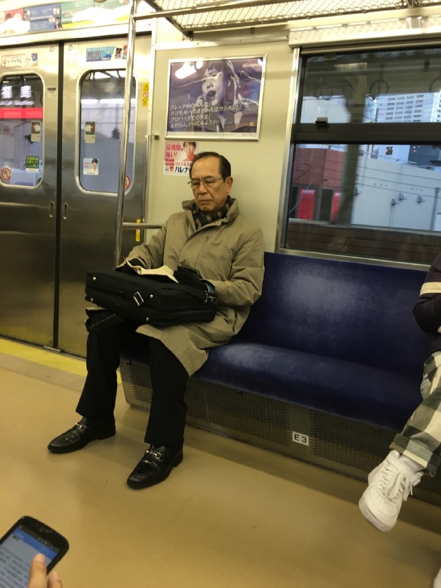 地铁上的老爷爷在看书.