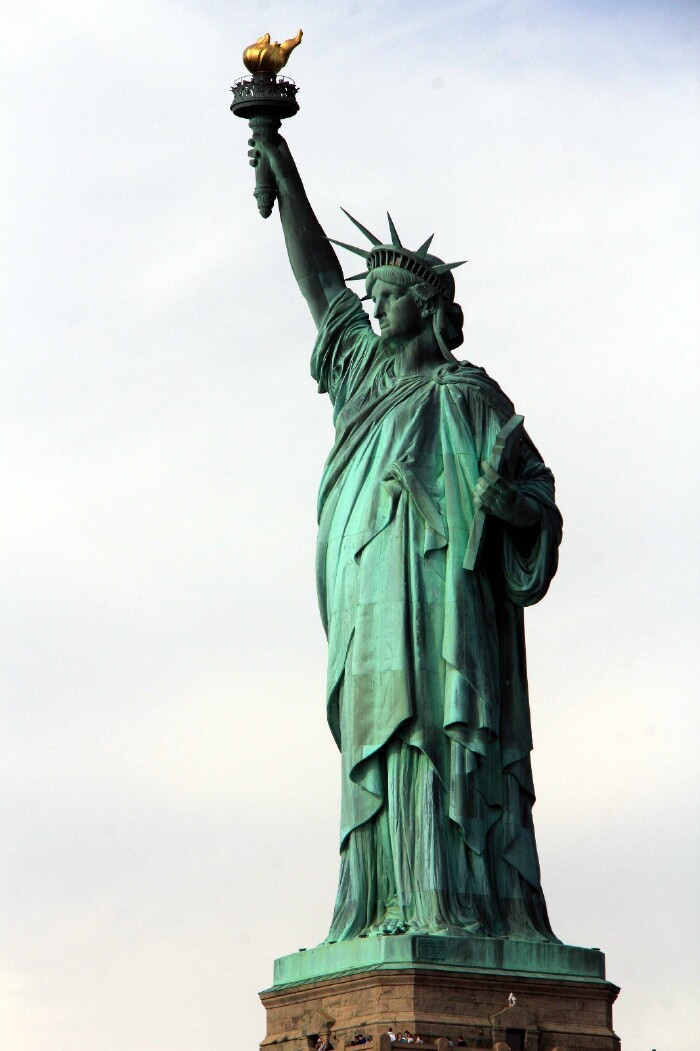 自由女神穿着古希腊风格服装,头戴光芒四射冠冕,七道尖芒象征七大洲.