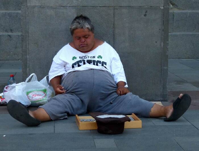 这位乞丐,一边乞讨,一边睡觉.