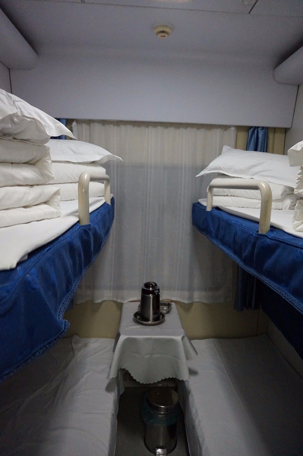 软卧车厢每间房间里有4个床位,床单和枕头是放在上铺的位置,下铺的两