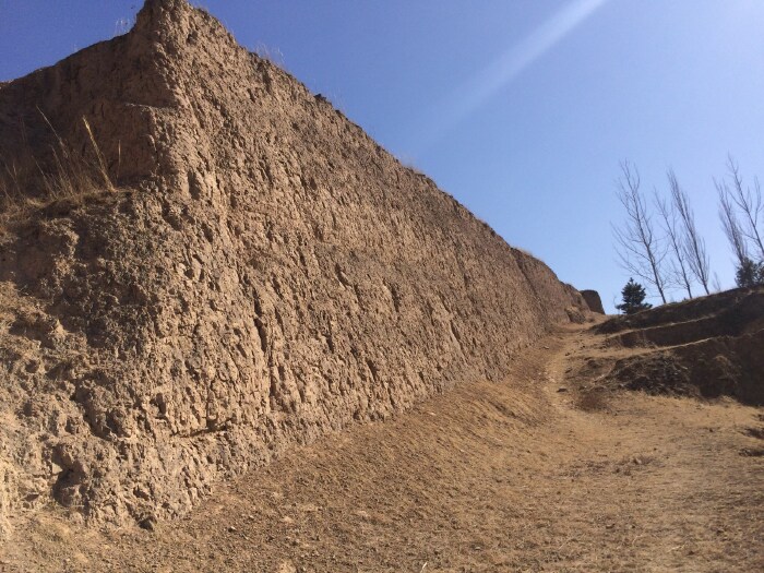我走在墙角,顺着土墙的走势往山上攀,看那些斑落的黄土,我才意识到这