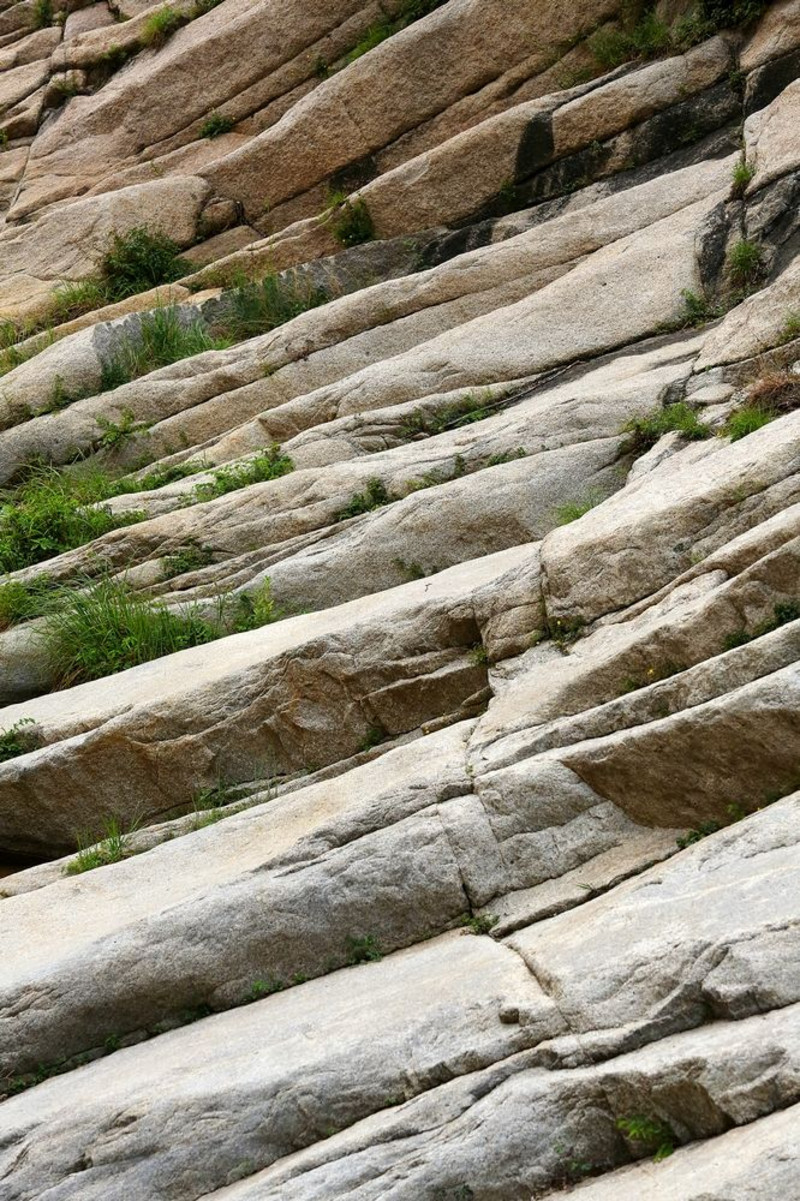 "鱼鳞坡"为花岗岩的节理,在风化时呈层形剥落,形似鱼鳞,谷中溪水漫流