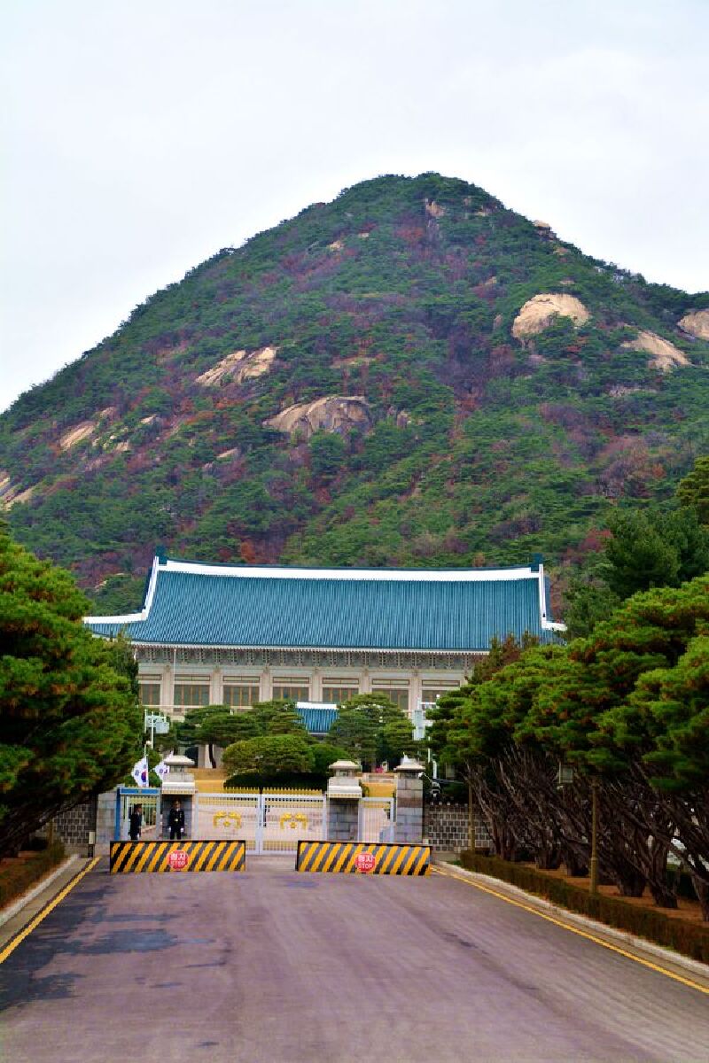 青瓦台的标志是多达15万枚的深蓝色瓦片,它的背后耸立着北岳山,给人的