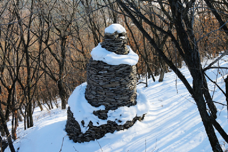 站在小的石塔堆中欣赏远处冬季美景.