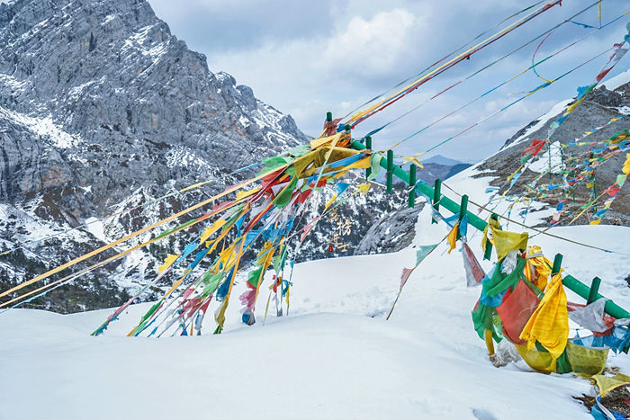 雪山上的风马旗,在大地与苍穹之间飘荡摇曳,构成了一种连地接天的境界