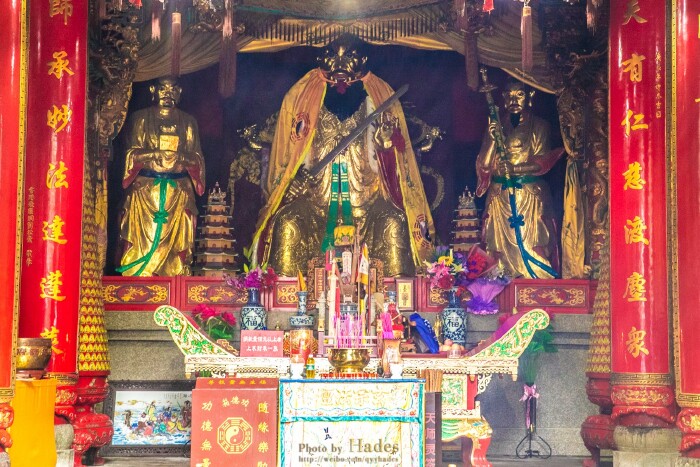 正厅中央供奉着三尊神像,中间在刀剑斧戟和龙虎旌旗拥下仗剑危坐的是