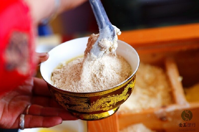 吃糌粑时,碗里放上一些酥油,冲入奶茶,加点糌粑面,用手不断搅匀.