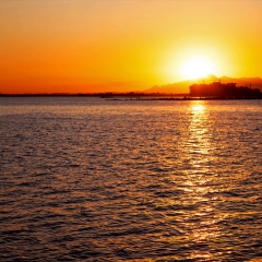 红色夕阳照映下的大海和城市的海岸线_3923