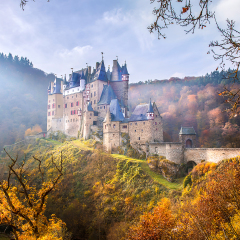 Mountain castle in autumn mountain forest