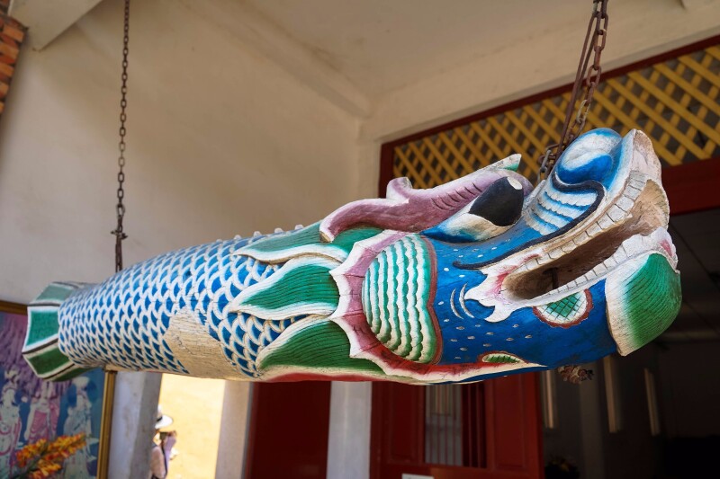 门内,悬挂着色彩斑斓的木质龙型雕刻,小胡介绍说这个是用来撞钟的钟杵