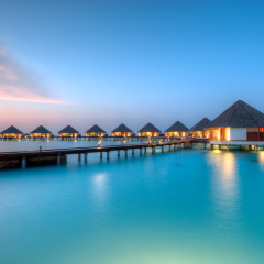 Water villas on Maldives resort island in sunset