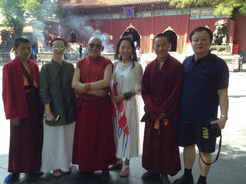 藏传佛教弟子和上师在雍和门大殿前留影双檐四角亭内是四面皇帝御碑