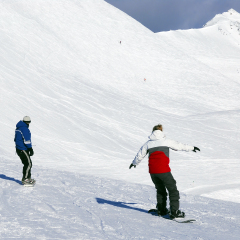 Couple snowboarding on the backdrop of scenic view in Canadian Rocky mountains ski resort