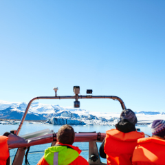 Sailing between icebergs in Jokulsarlon Lagoon, Iceland. Crowd on amphibian tour among melting glaciers.