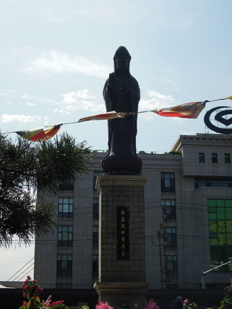 观世音菩萨立在般若寺内,游客前来跪地叩拜.