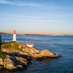 Aerial view of the Light House on a rocky shore. Taken in Lighthouse Park, West Vancouver, British Columbia, Canada, during a sunny sunset.