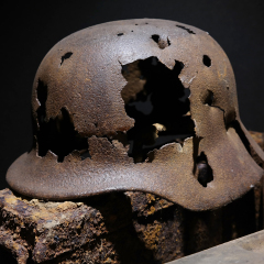 A rusty German World War II military helmet Pierced with bullets, remnant of the Battle of the Bulge, found in the ardennes. 