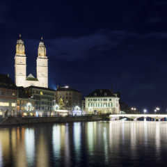 View of the Grossmunster (great minster) Church and the Limmat River at night, with a Christmas tree, in Zurich, Switzerland