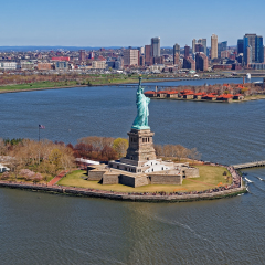 Aerial view of the Statue of Liberty in New York City, USA with Downtown Brooklyn and Governors island in the background. The statue is an icon of freedom and of the United States