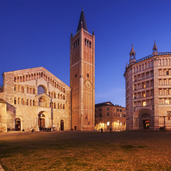 Parma Cathedral (Duomo) and the beautiful Baptistery (Battistero) in Emilia Romagna, Italy, illuminated at dusk.