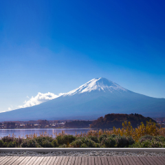 fuji mountain and lake kawaguchiko with blue sky background view from wood terrrace floor, Yamanashi Prefecture, Japan. the sacred mountain of Fuji and symbolic of Japanese