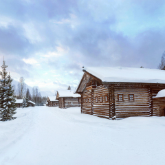 Old Village Log Houses in museum Small Karelians near Arkhangelsk, Russia. Winter sunset time.