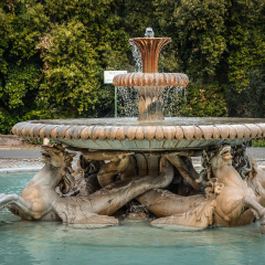 Old marble fountain in a dark park. Pincio park, Rome. Italy