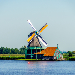 View from the Zaan River of Dutch Windmills and Historic Houses at the old fishing villages of Zaanse Schans and Zaandijk in the Netherlands