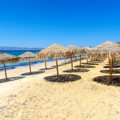 Parasols on Agia Anna beach, one of the best organized beaches of Naxos.  Cyclades Islands, Greece.	