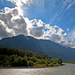 View of the Squamish River at Brackendale Eagles Provincial Park in British Columbia, Canada with sun flare behind dramatic clouds