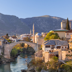 Skyline of Mostar with the Mostar Bridge, houses and minarets, at the sunset in Bosnia and Herzegovina.