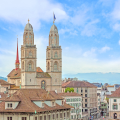 The Grossmunster with town hall in front. It is a Romanesque-style Protestant church in Zurich, Switzerland. View from park Lindenhof.