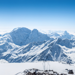 Snowy Greater Caucasus ridge with the Mt. Ushba at winter sunny day. Panoramic view from Pastuchova kliffs at Elbrus ski slope, Kabardino-Balkaria, Russia