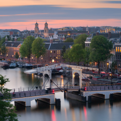 The Magere Brug (also known as Skinny Bridge) is a bridge over the river Amstel in the city centre of Amsterdam, Netherlands. Rooftop view at sunset.