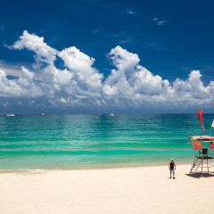 young man walking on a tropical beach. Sanya, Hainan island, China.