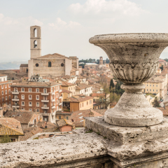 cityscape. aerial view of old houses and the Basilica di San Domenico against a blue sky background in old town of Perugia,  Italy. photography from viewing platform with stone parapet, decoreted vase